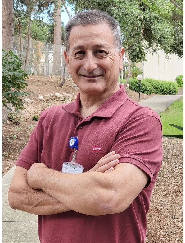 Dr. Avi Chezar, orthopedic shoulder surgeon, standing outdoors with his hospital badge